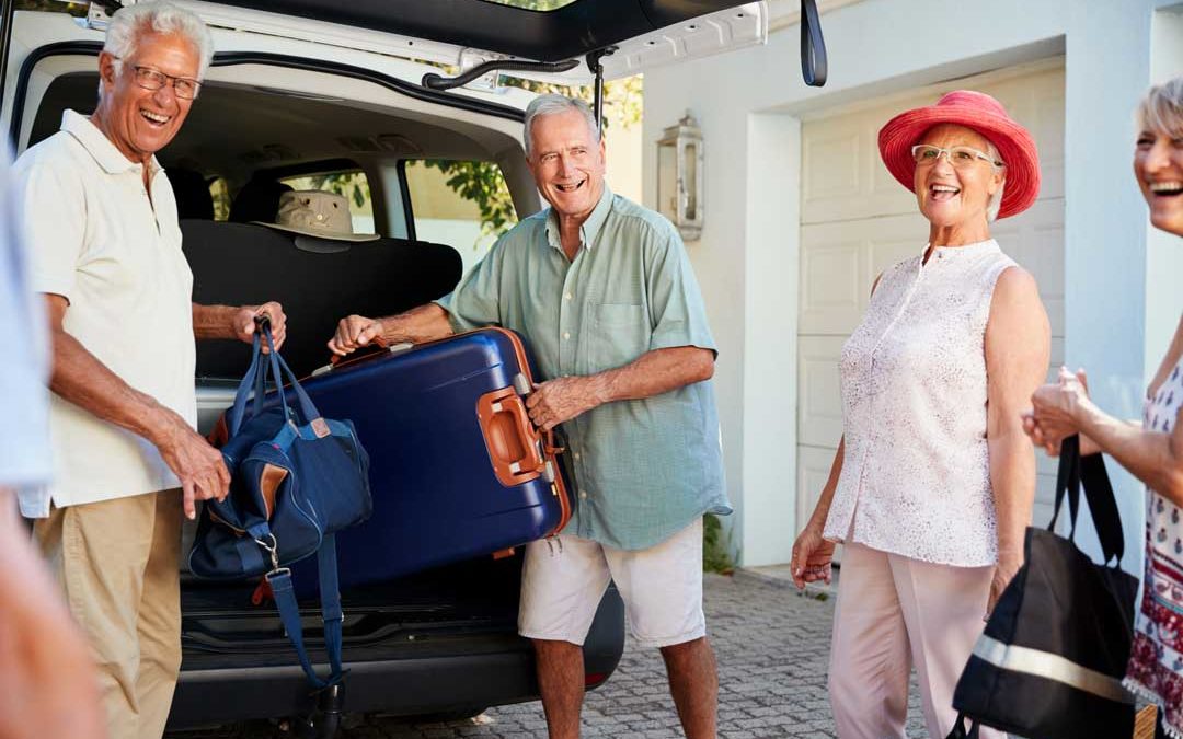 group of senior friends unloading luggage at vacation rental